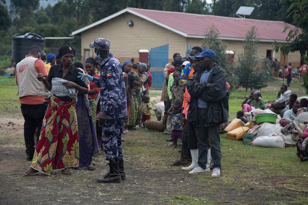 A Ugandan police officer speaks to a group of asylum-seekers from the Democratic Republic of the Congo at the Nyakabande Tansit center in Kisoro, Uganda, on November 10, 2021.