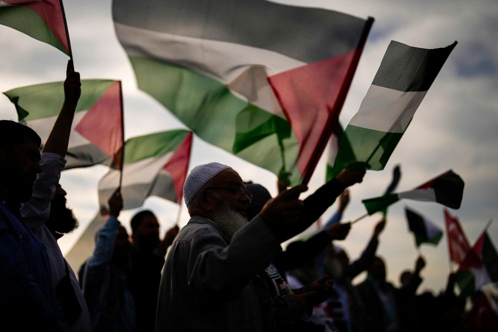 AP Photo/Francisco Seco Illustration - Des manifestants pro-palestiniens brandissent des drapeaux palestiniens