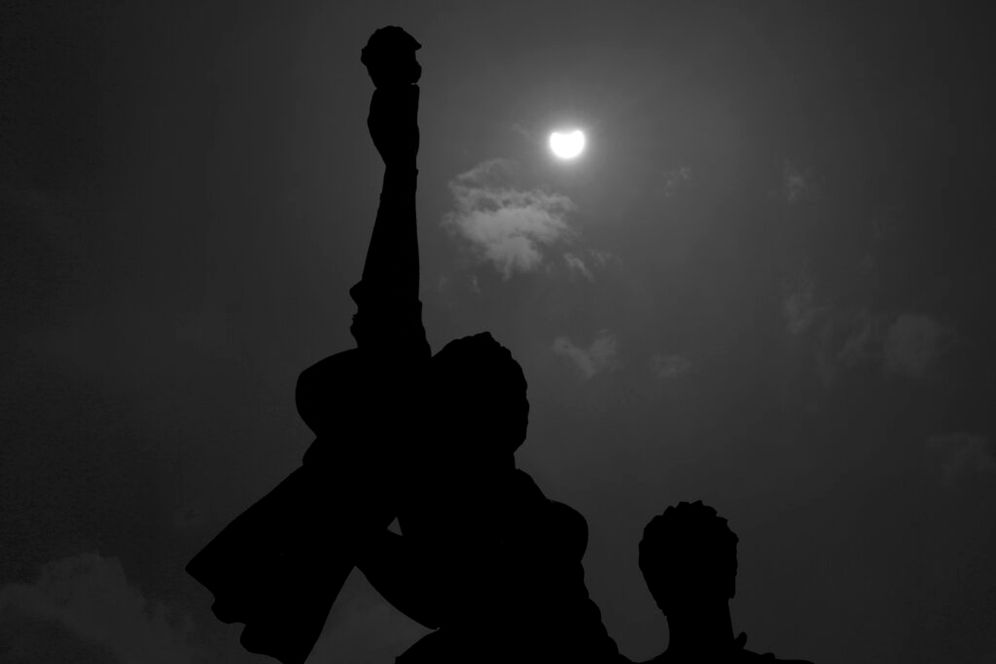 A partial solar eclipse is seen behind the Statue of Martyrs in downtown Beirut, Lebanon.