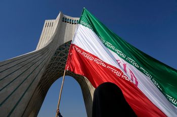 يُحمل علم إيراني ضخم تحت برج آزادي (الحرية) التذكاري خلال المسيرة السنوية لإحياء ذكرى الثورة الإسلامية الإيرانية عام 1979 في طهران، إيران، الأحد 11 فبراير 2024