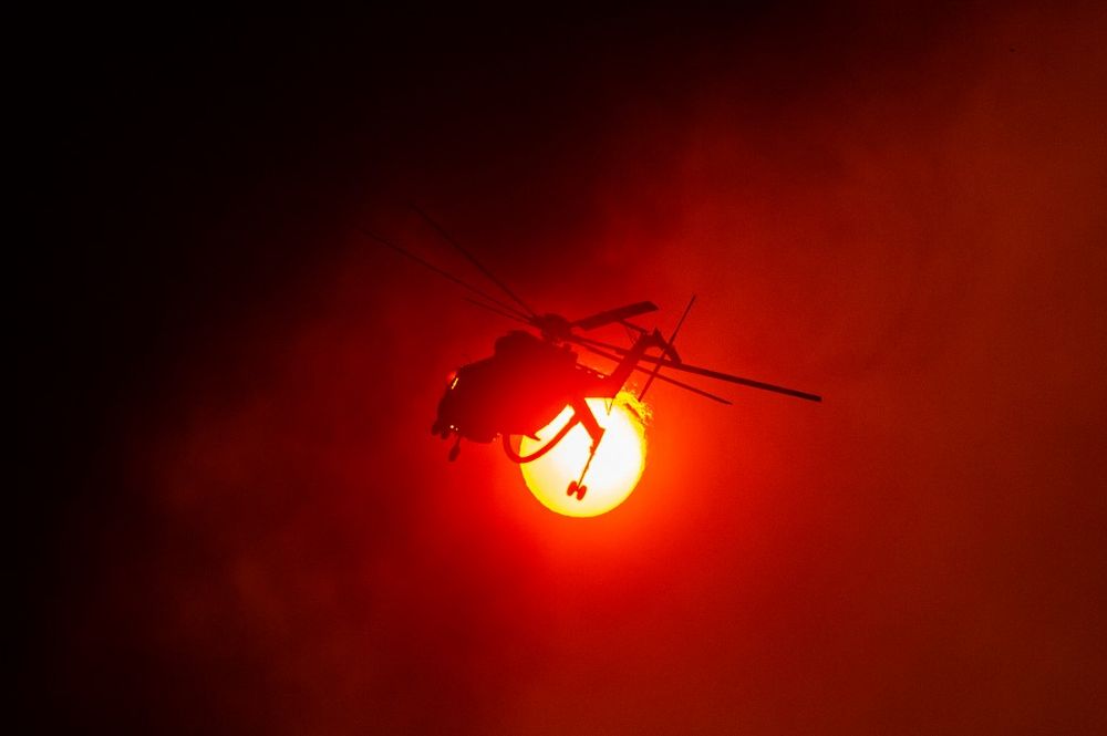 A firefighting helicopter operates in the village of Villa, northwestern Athens, Greece, on August 18, 2021.
