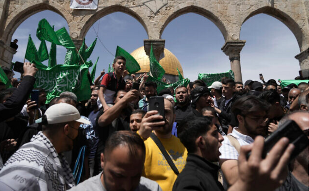 Des Palestiniens scandent des slogans et agitent des drapeaux du Hamas après la prière du vendredi pendant le mois sacré du Ramadan, sur le Mont du Temple, dans la vieille ville de Jérusalem, le 22 avril 2022.