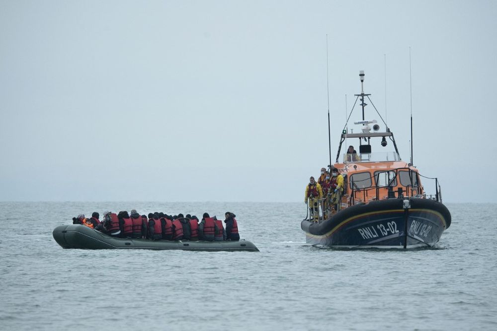 Des migrants sont aidés par un bateau de sauvetage de la RNLI avant d'être emmenés sur une plage à Dungeness, sur la côte sud-est de l'Angleterre, le 24 novembre 2021.