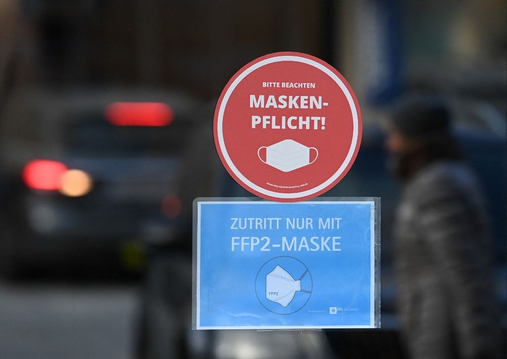 A sign for mandatory wearing of FFP2 face protection masks is seen at the entrance of a shop in the city of Eggenfelden, southern Germany, on November 24, 2021.