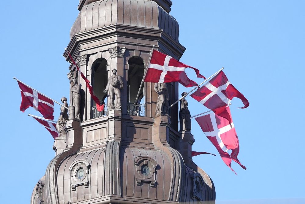 Danish flags wave in the spire of the Christiansborg Castle, the Danish Parliament building, in Copenhagen, Denmark, on September 5, 2021.