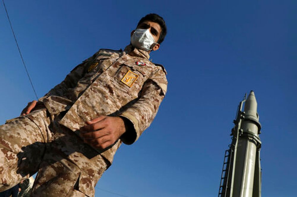 An Islamic Revolutionary Guard Corps member walks past Qiam missile displayed in a missile capabilities exhibition, in Tehran, Iran, January 7, 2022.