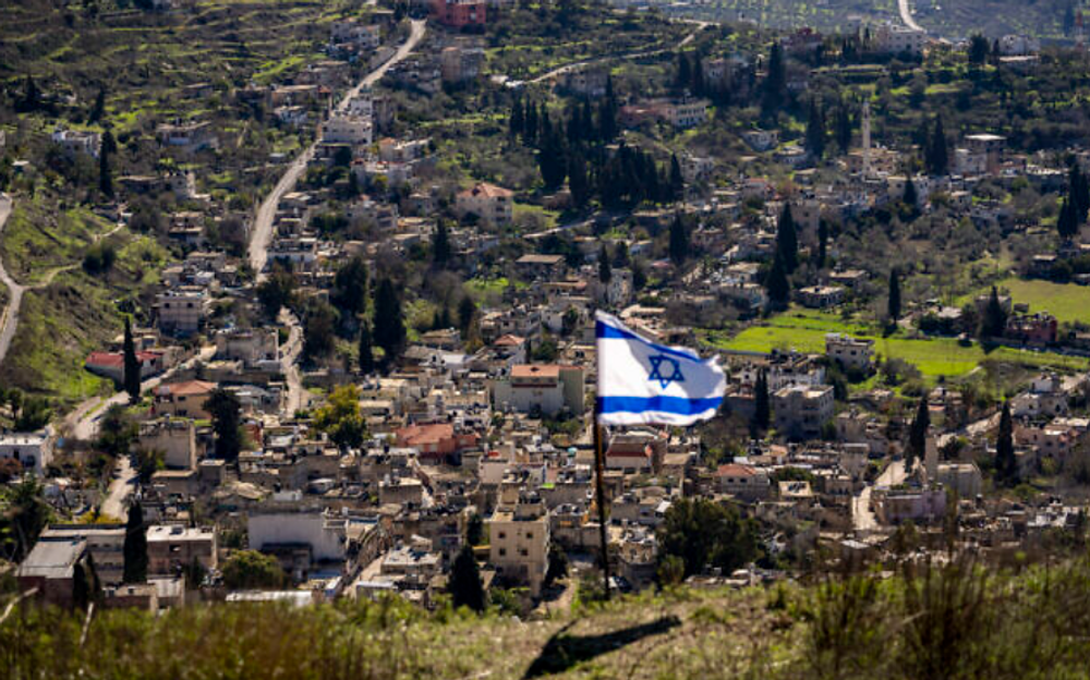 The village of Burqa is seen as an Israeli flag is placed in the Jewish outpost of Homesh in the West Bank, January 17, 2022.