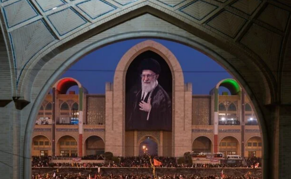 AP/Altaf Qadri Des personnes en deuil se rassemblent sous un portrait du défunt Guide suprême iranien, l'ayatollah Ali Khamenei, lors des cérémonies funéraires organisées en son honneur et en celui des membres de sa famille, à la grande mosquée Imam Khomeini Mosalla, à Téhéran (Iran), le 4 juillet 2026.