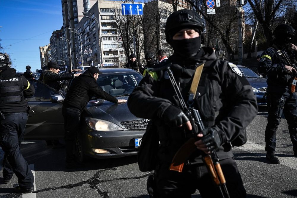 Ukrainian policemen stop cars to control people as they look for suspicious men, on February 27, 2022, on a street in Kyiv, Ukraine.