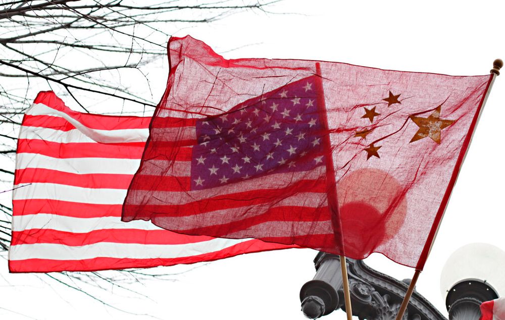 American (L) and Chinese flags fly in front of the White House in Washington, United States.