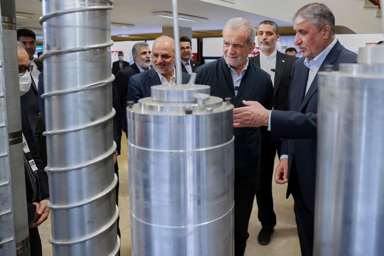 FILE - In this photo released by the Iranian Presidency Office, President Masoud Pezeshkian, second right, listens to head of Atomic Energy Organization of Iran Mohammad Eslami as he visits an exhibition of Iran's nuclear achievements, in Tehran, Iran, April 9, 2025.