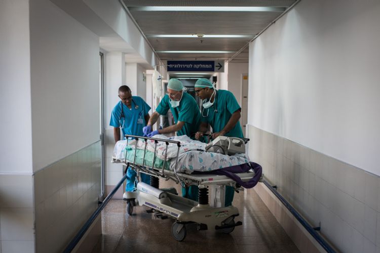 Doctors and nurses take a child patient to the emergency room for recovery after undergoing open-heart surgery at Wolfson Medical Center in Holon, Israel, on August 13, 2018.