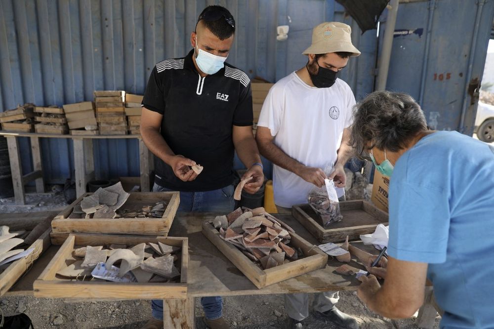 Employees of the Israel Antiquities Authority collect ceramic fragments at an excavation site in Jerusalem on July 22, 2020.