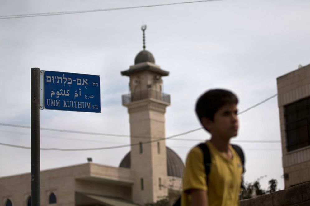 ASSOCIATED PRESS ילד עובר ליד שלט "רחוב אום כולתום" במזרח ירושלים, ארכיון