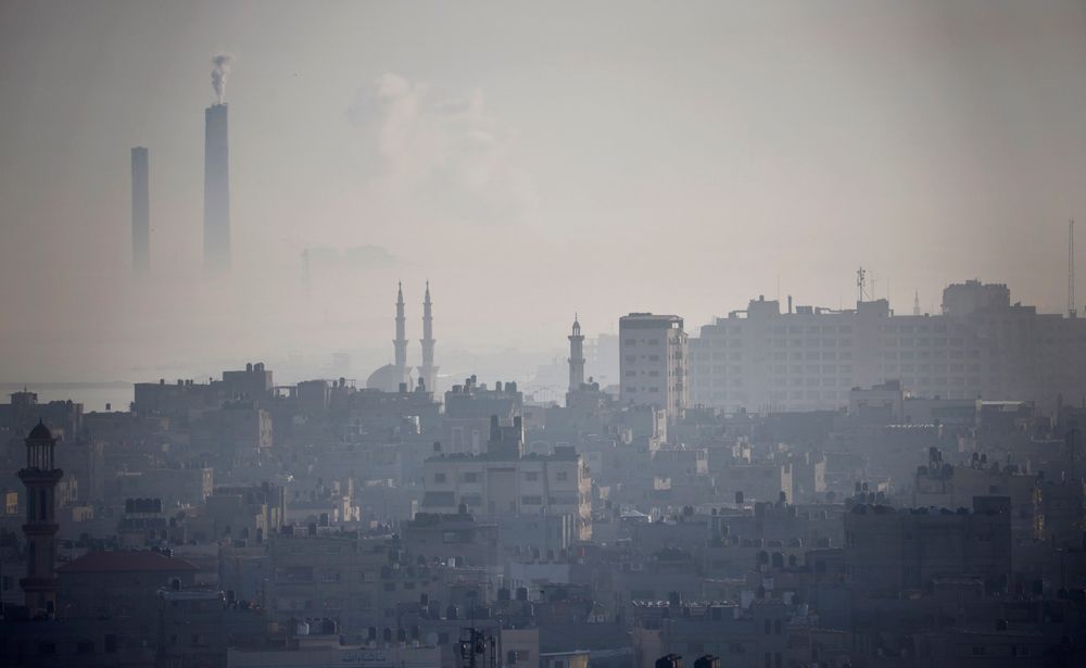 Des bâtiments au nord de la bande de Gaza à l'aube avec en arrière-plan, les deux cheminées de la centrale israélienne d'Ashkelon (en haut à gauche), le 16 mai 2019