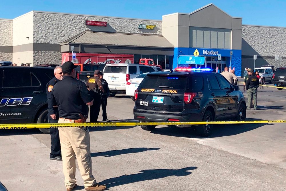 Law enforcement work the scene where two men and a woman were fatally shot Monday, Nov. 18, 2019, outside a Walmart store in Duncan, Oklahoma