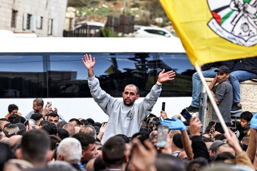 Un des prisonniers palestiniens libérés par Israël entouré par une foule en liesse après être descendu d'un des bus de la Croix-Rouge à Ramallah en Judée-Samarie le 25 janvier 2025.