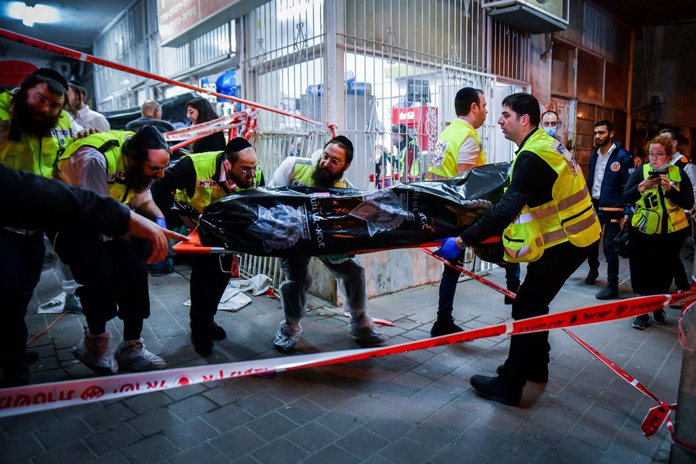 Des membres de l'organisation Zaka transportent un corps sur les lieux d'un attentat à Bnei Brak, le 29 mars 2022