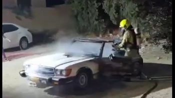 Firefighter putting out a car that was set ablaze in the Jerusalem neighborhood of Issawiya