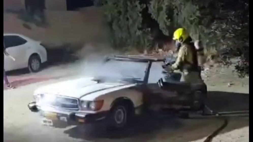 Firefighter putting out a car that was set ablaze in the Jerusalem neighborhood of Issawiya