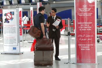 يقوم موظفو المطار بإبلاغ الركاب عند مدخل نقطة التفتيش الجوية بين الدار البيضاء ونيويورك في مطار محمد الخامس الدولي بالدار البيضاء