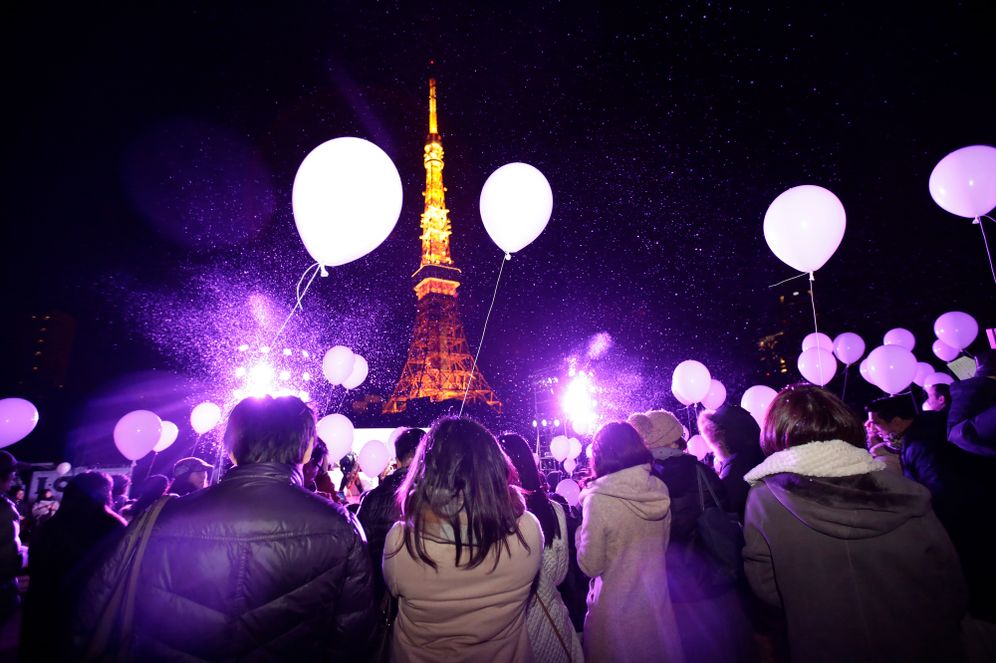 AP Photo/Eugene Hoshiko Peoples wait to release balloons to celebrate the New Year with Tokyo Tower in the background in Tokyo, late Thursday, Dec. 31, 2015. Japan celebrated the start of 2016, the Year of the Monkey in the Japanese Zodiac