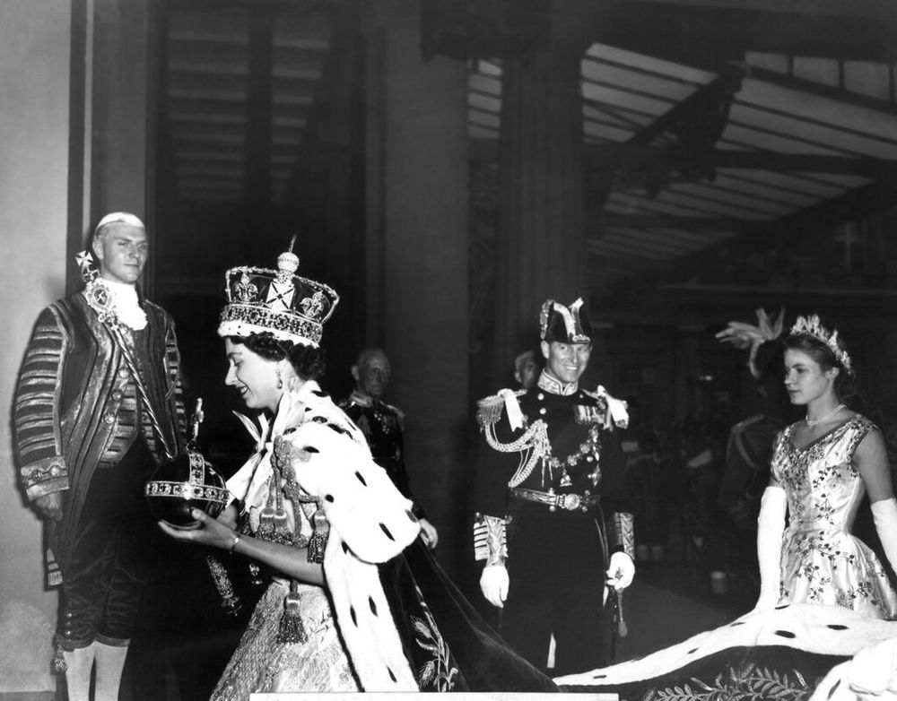 Queen Elizabeth II, carrying the orb and the scepter, enters Buckingham Palace after the Coronation ceremony in London's Westminster Abbey, England, on June 2, 1953.
