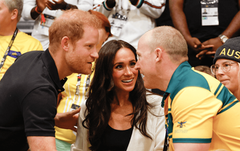 Meghan et le prince Harry saluent un spectateur australien alors qu'ils prennent place pour assister à une compétition de basket-ball en fauteuil roulant lors des Invictus Games 2023 à Duesseldorf, dans l'ouest de l'Allemagne, le 13 septembre 2023.