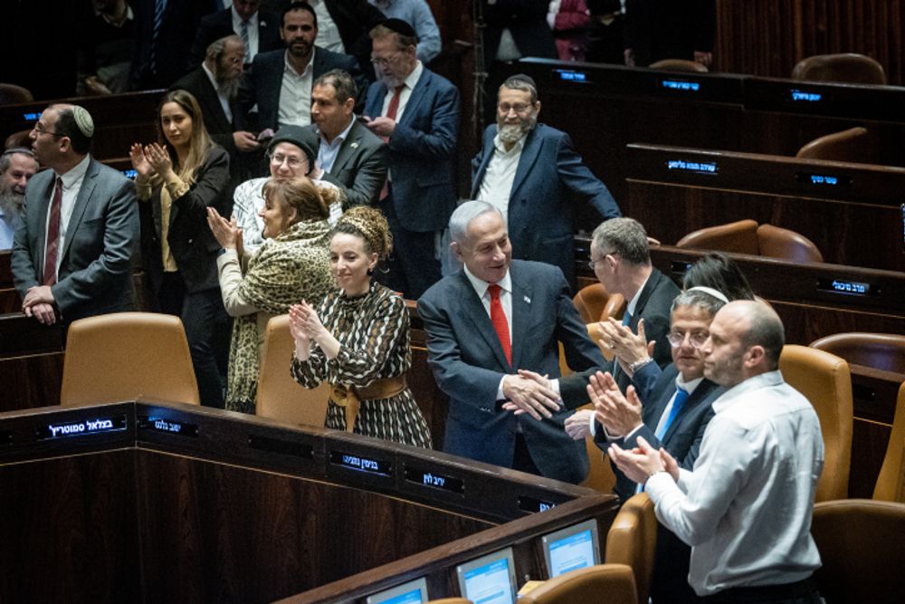 Israeli Prime Minister Benjamin Netanyahu, Justice Minister Yariv Levin and coalition members celebrate the first reading vote on part of the justice reform in the Knesset.