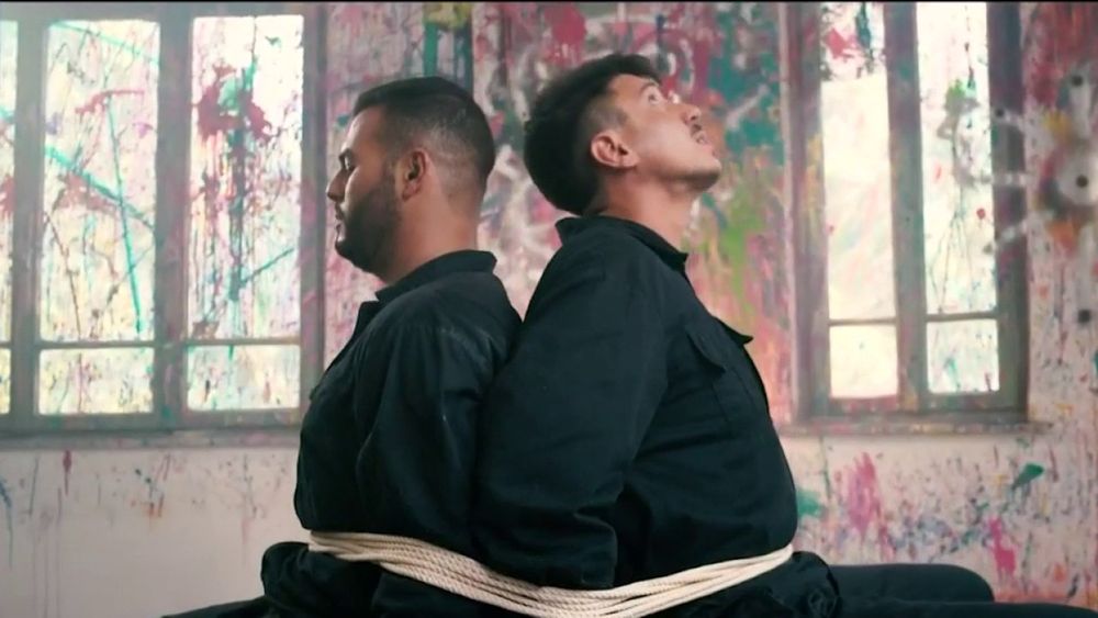 Rap group Dugri's music video "Munfas" shows group members Sameh Zakout (L) and Uriya Rosenman bound to each other by a rope, in a screen capture taken on November 29, 2021.