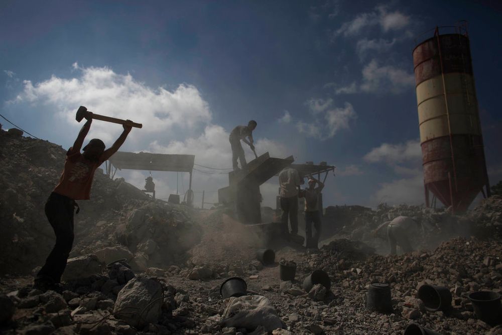Palestinians work to recycle cement at a factory east of Jebaliya, Gaza Strip.