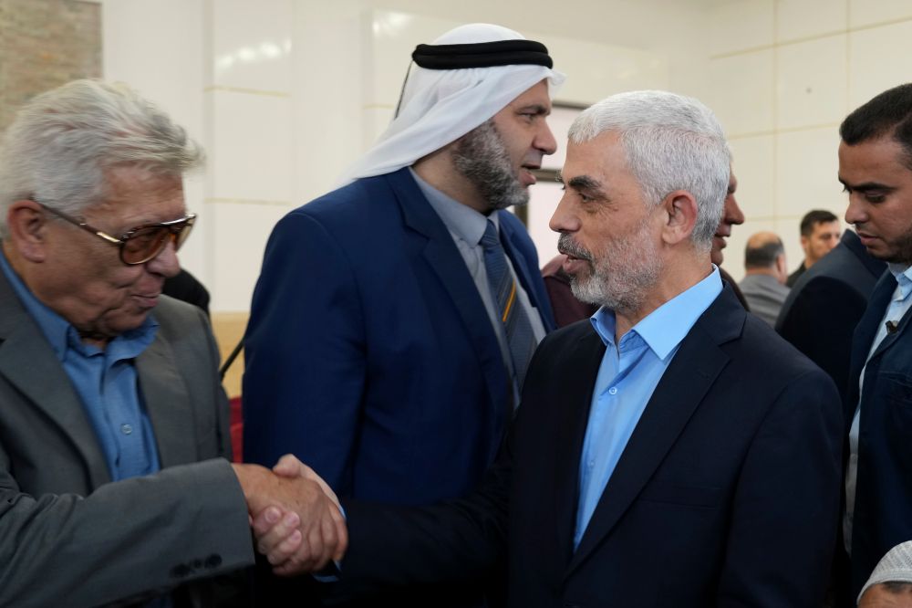 Yahya Sinwar, head of Hamas, shakes hands with his supporters upon his arrival to a meeting with people at a hall on the sea side of Gaza City