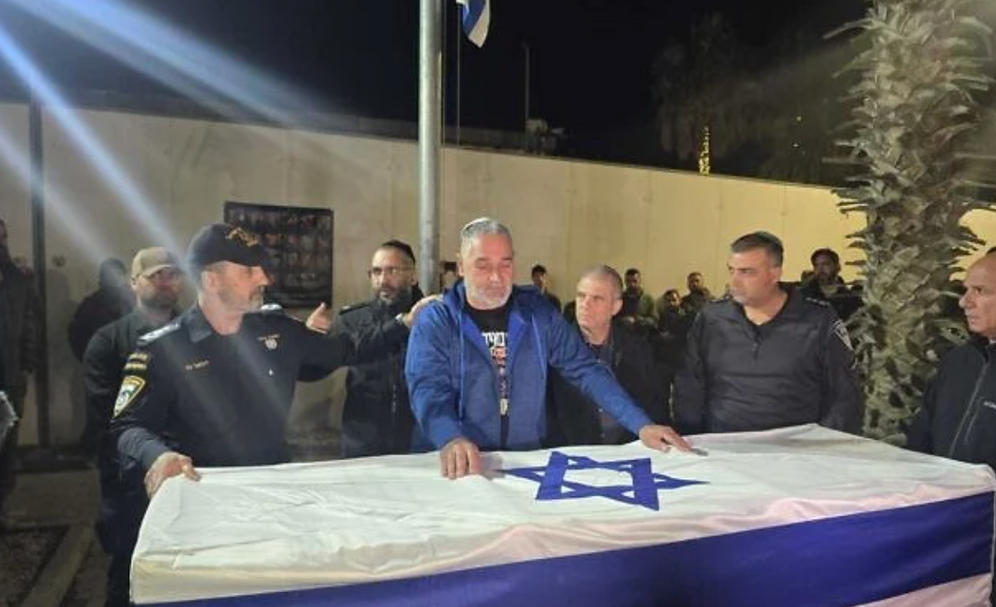 Le chef de la police Daniel Levy (à gauche) et Itzik Gvili (au centre) lors d'une cérémonie organisée par la police israélienne en hommage à son fils, le sergent-chef Ran Gvili, assassiné lors d'une prise d'otages, à la base Nahal de l'armée israélienne, le 26 janvier 2025.