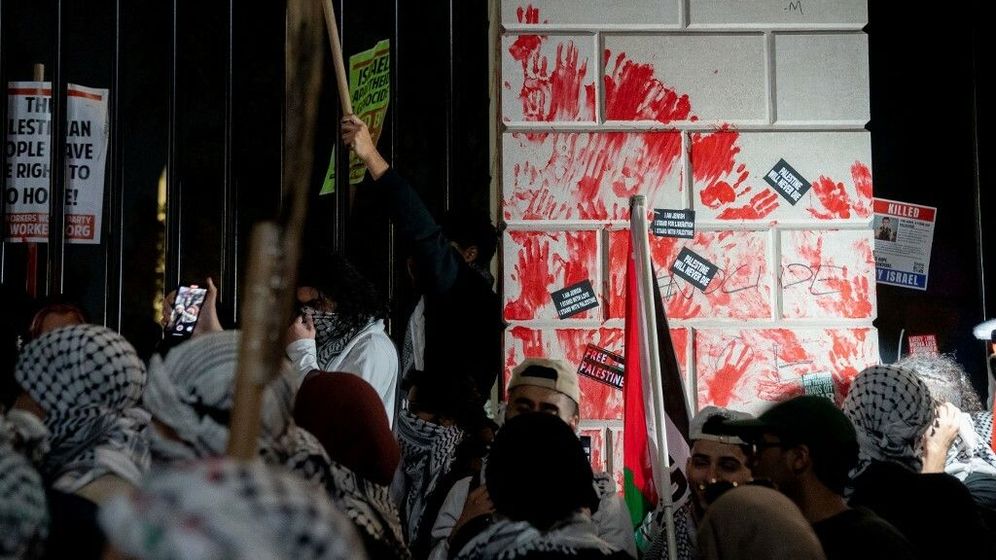 Demonstrators leave red hand prints on the fence in front of the White House during a rally in support of Palestinians in Washington, DC.