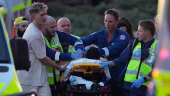 Emergency workers transport a person on a stretcher after a reported shooting at Bondi Beach, in Sydney, Sunday, Dec. 14, 2025