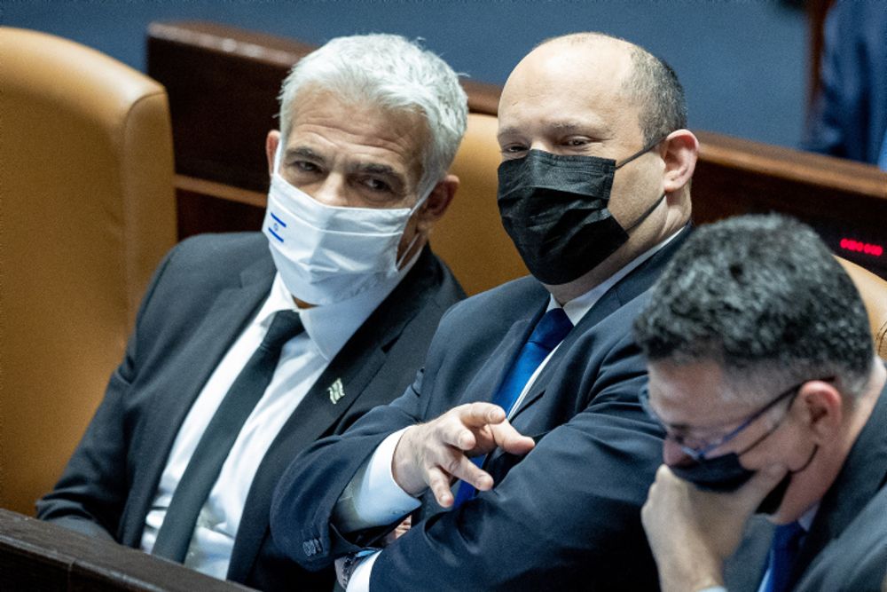Israel's Prime Minister Naftali Bennett (C), Foreign Minister Yair Lapid (L) and Justice Minister Gideon Saar attend a plenum session, in the assembly hall of the Israeli parliament in Jerusalem, January 17, 2022.