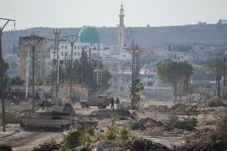 Israeli army armored vehicles block a road leading to the town of Quneitra, Syria
