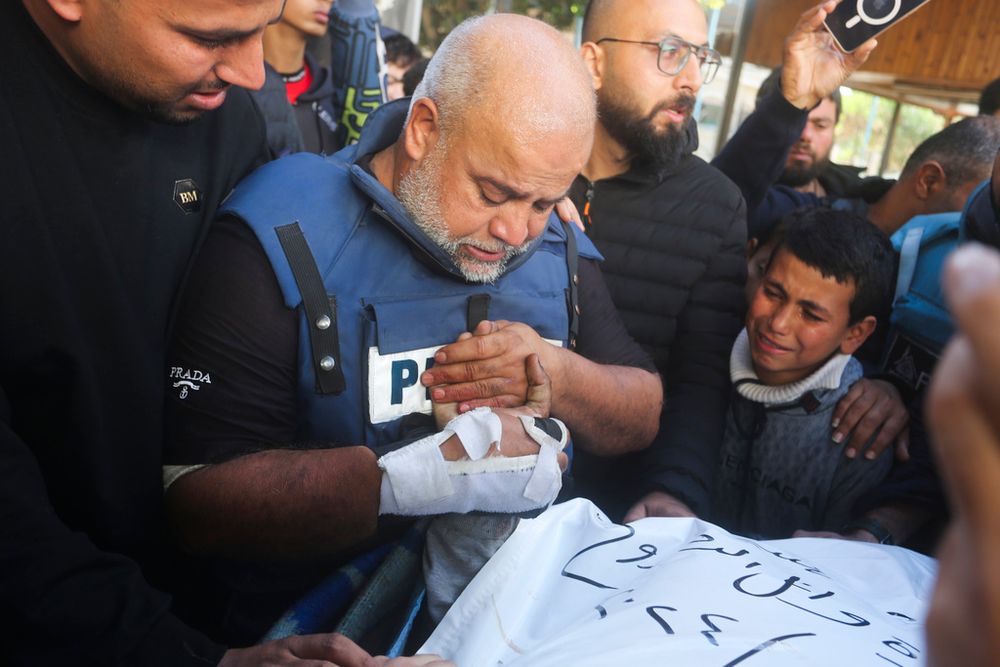 Al Jazeera journalist Wael Dahdouh holds the hand of his son Hamza, who also worked for Al Jazeera and who was killed in an Israeli airstrike in Rafah, Gaza Strip, Sunday, Jan. 7, 2024.