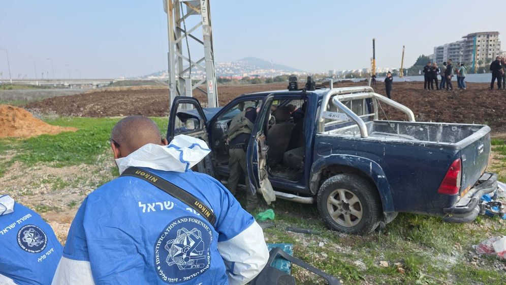 Israeli security officers search the assailant's vehicle 