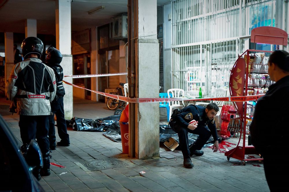 Israeli police officers and rescue forces are seen at the scene of a shooting attack in Bnei Brak, March 29, 2022.