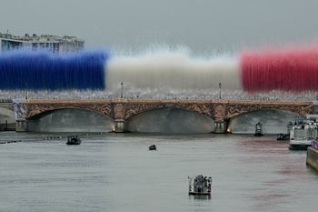 Des feux d'artifice aux couleurs nationales françaises explosent au-dessus du Pont d'Austerlitz lors de la cérémonie d'ouverture des Jeux Olympiques de Paris 2024, à Paris, le 26 juillet 2024