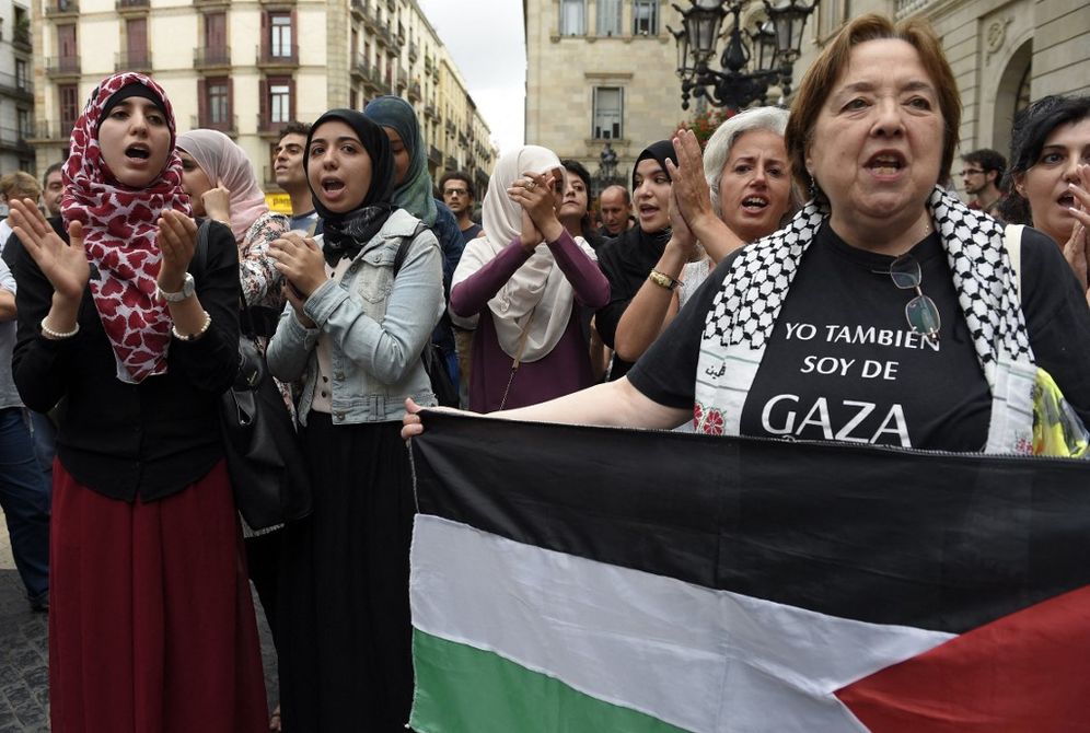 People take part in a demonstration in support of Palestinians at Sant Jaume square, in Barcelona, Spain.
