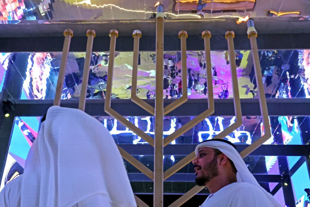 Emiratis stand in front of a large menorah at Israel's Expo 2020 Pavilion in the Gulf emirate of Dubai, UAE, on November 28, 2021, during the Jewish festival of Hanukkah.