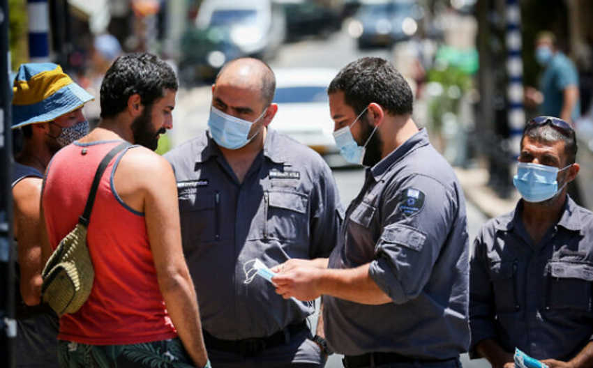Des inspecteurs parlent à un homme ne portant pas de masque facial dans la ville de Safed, dans le nord du pays, le 15 juin 2020.