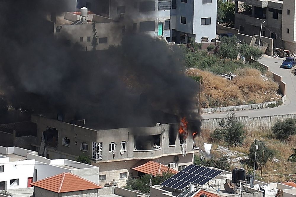 Smoke billows from a building in the West Bank city of Jenin on May 13, 2022 during an Israeli military raid.