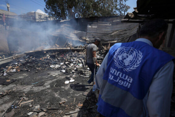 Des Palestiniens observent les dégâts causés par une frappe israélienne sur une école gérée par l'UNRWA, à Nuseirat, dans la bande de Gaza, le 14 mai 2024.