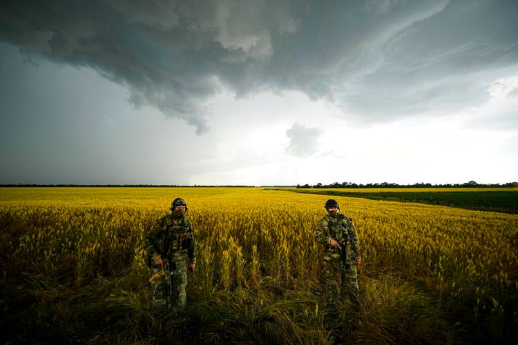 Russian soldiers guard an area next to a field of wheat as foreign journalists work in the Zaporizhzhia region in an area under Russian military control, southeastern Ukraine, on June 14, 2022.