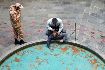 An Iranian Revolutionary Guard soldier looks at an exhibition at a former prison, now a museum, where a wax mannequin of an interrogator is depicted forcing a prisoner’s head under water, in Tehran, Iran.