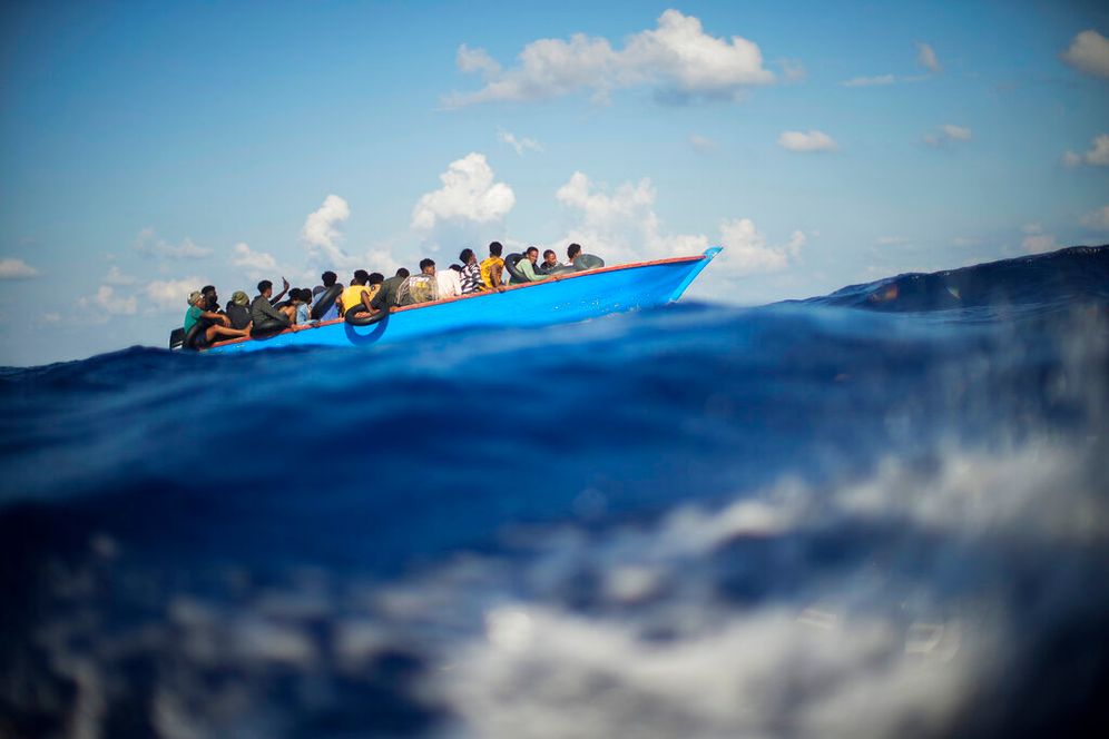 Migrants in a wooden boat float in the Mediterranean Sea south of the Italian island of Lampedusa.