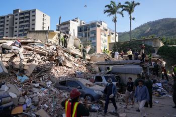 Residents and rescue workers search through the rubble of a building that collapsed in an earthquake in Caracas, Venezuela, Thursday, June 25, 2026. 